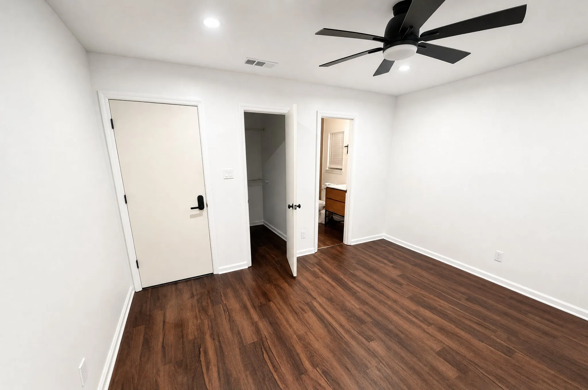 A bedroom with new trim and doors, opening through to an ensuite.