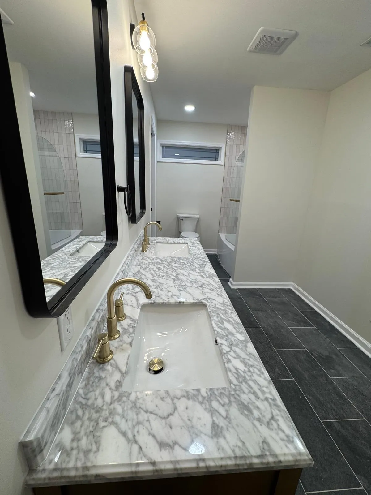 Carrara marble worktop and basin detail, with the bathroom reflected in the mirror above.