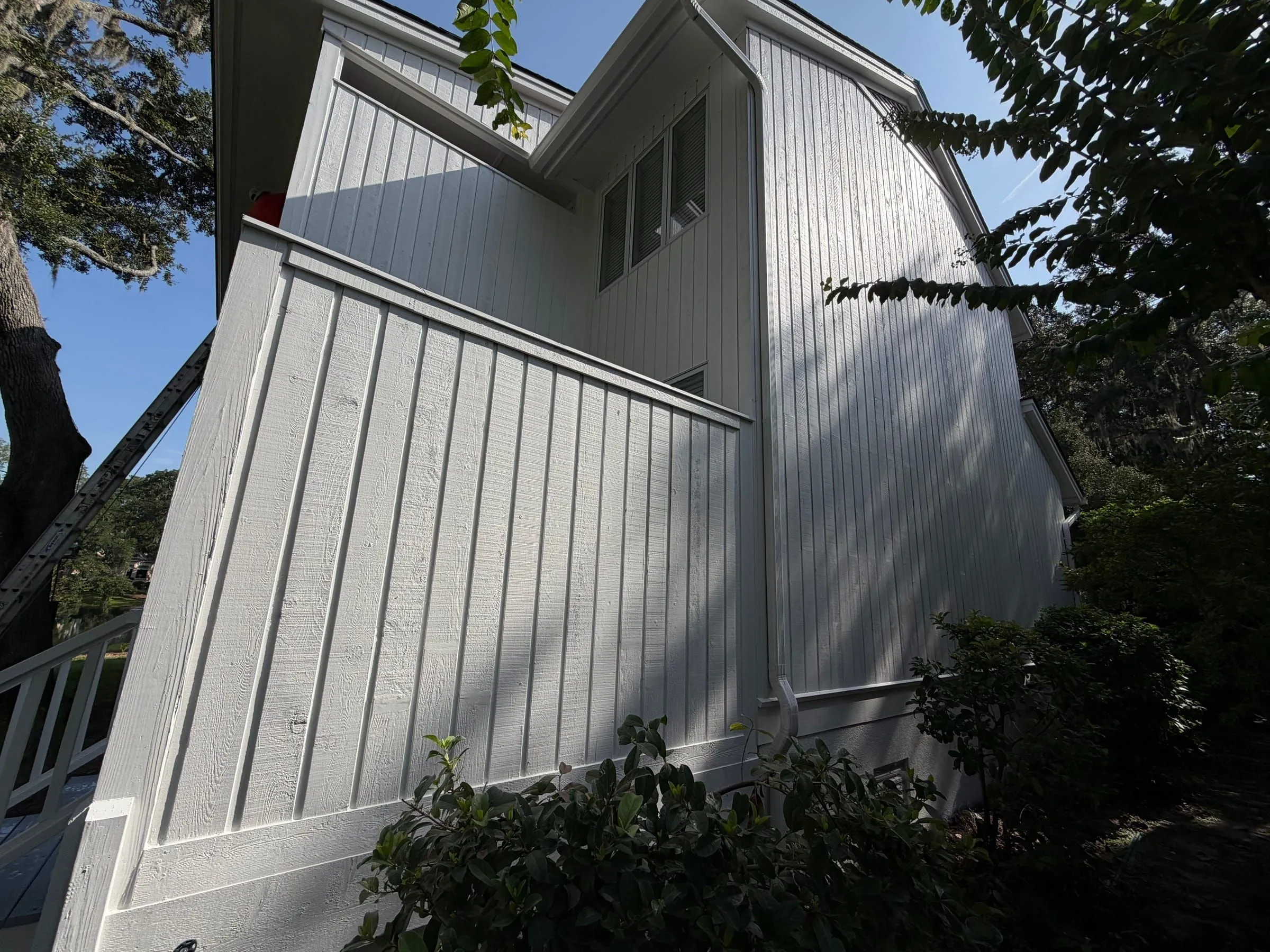 Board-and-batten siding running up into the gable, trim and battens cut in by hand.