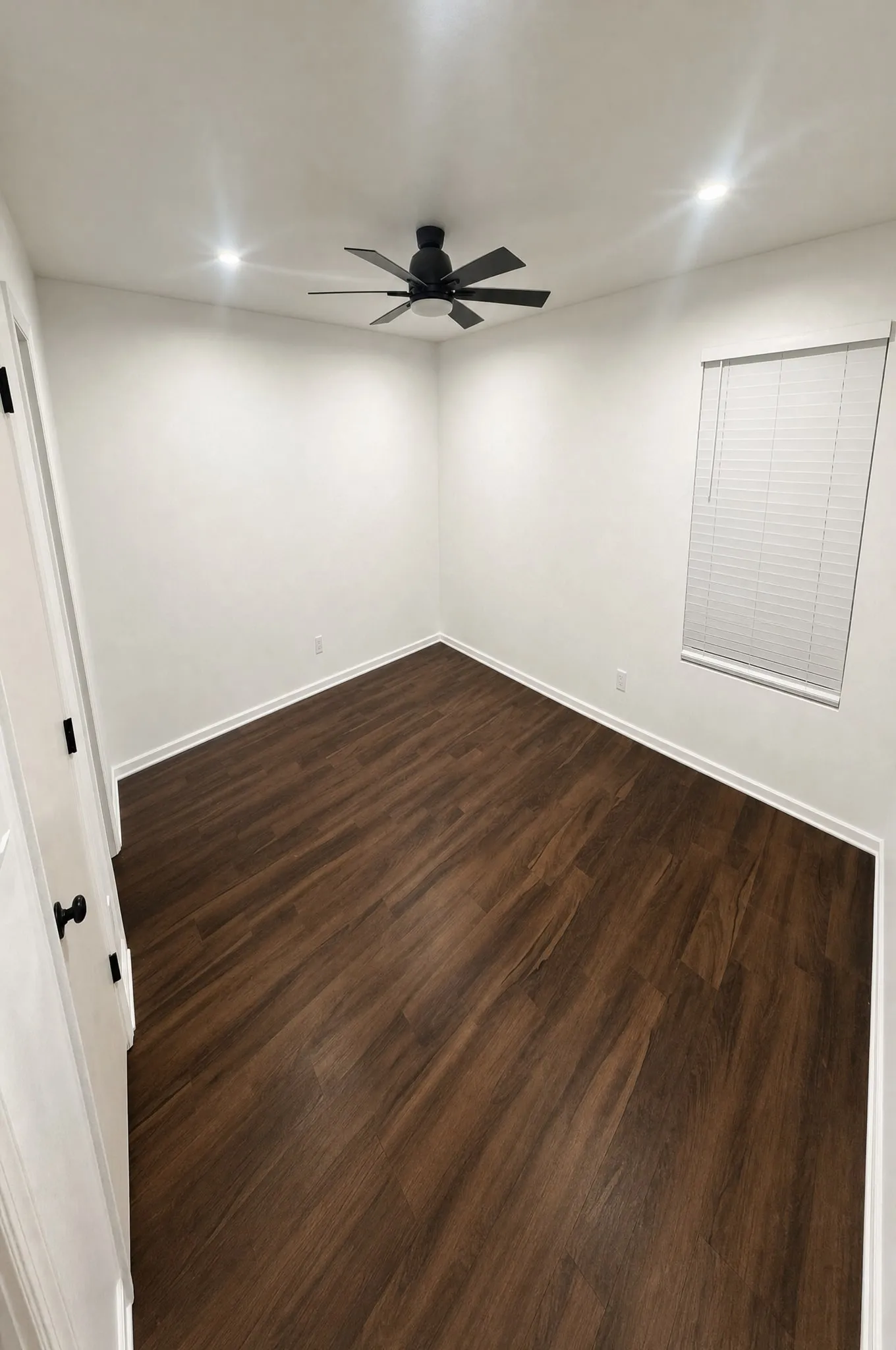 A guest room with new flooring laid corner to corner and fresh white trim.