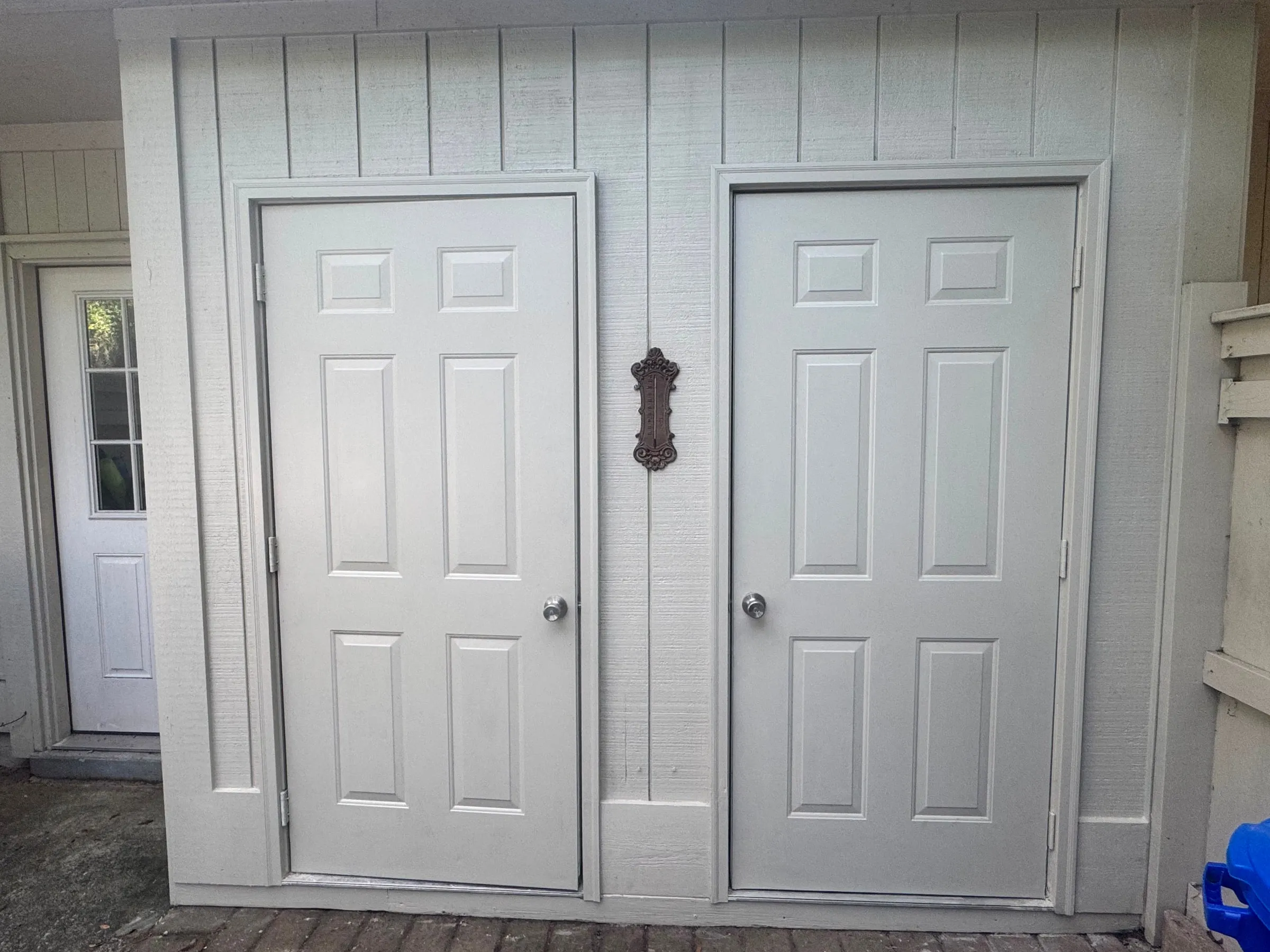A pair of panelled side doors in repaired casings, with the original hardware kept.