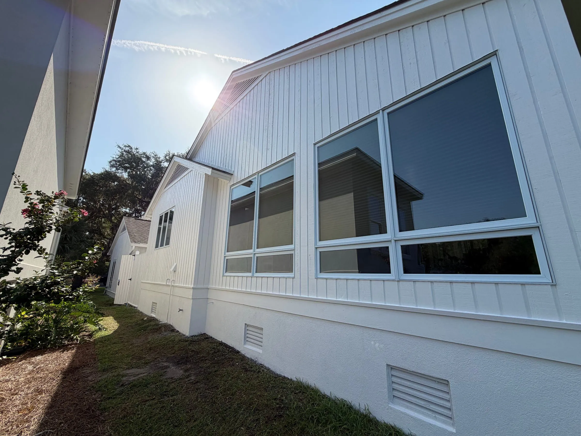The side elevation, a run of windows above the stucco base and the vents set into it.