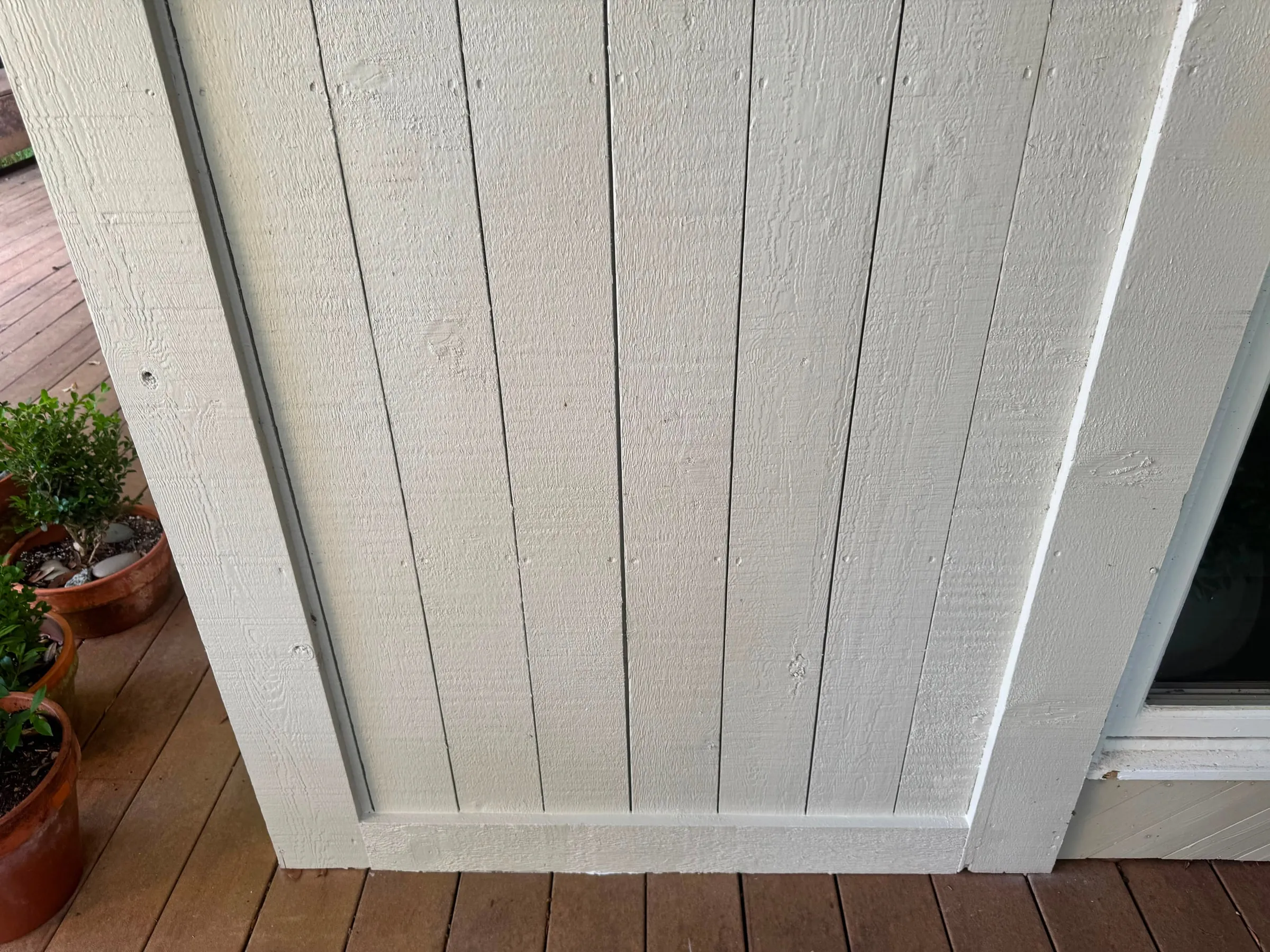 Board-and-batten siding and soffit after repair, with the new paint matched to the old.
